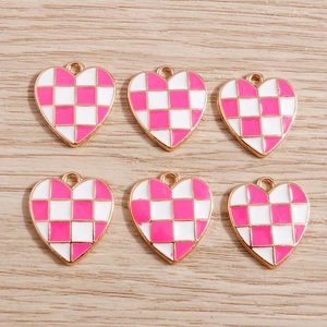 Detailed macro view of heart-shaped checkered enamel charms for DIY jewelry making