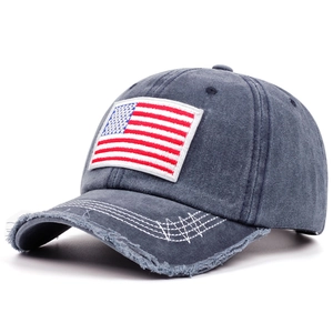 Dettaglio cappello baseball in denim lavato con ricamo bandiera USA e tesa consumata