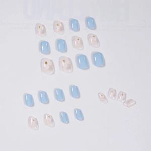 Short square light blue press-on nails with white floral patterns and golden glitter accents