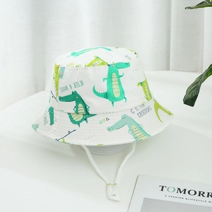 Détail d'un chapeau bob en coton blanc avec imprimé crocodile vert et cordon réglable