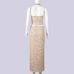 Dettaglio del set top corto a schiena scoperta e gonna lunga con paillettes oro champagne