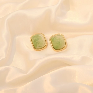 Square candy color stainless steel earrings with green marble inlay on white silk fabric