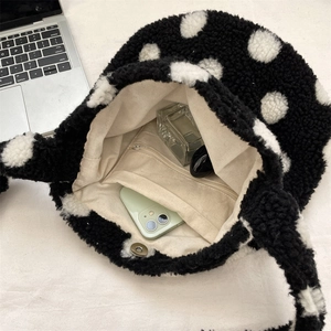 Détail de l'intérieur du sac seau en peluche à pois avec poche zippée et fermoir aimanté