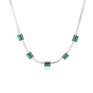 Macro shot of silver snake chain necklace featuring five rectangular emerald green zircons