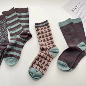 Detail of soft cashmere-feel socks with vintage plaid and houndstooth patterns