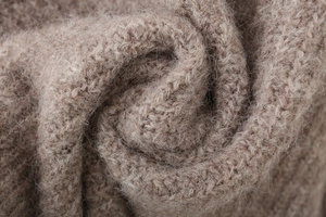 Macro shot of camel alpaca wool knit fabric showing soft texture and high-quality fibers