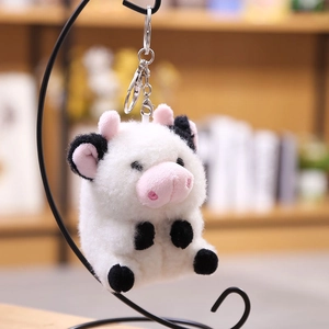 Lindo llavero de vaca de peluche con manchas negras y detalles rosas en gancho plata