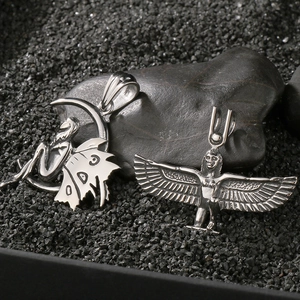 Detail view of silver vintage angel wings and Egyptian goddess Isis steel pendants