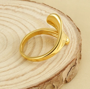 Detail of 18k gold plated stainless steel teardrop ring on a natural wood slice