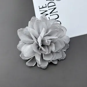 Detailed top view of a handmade grey layered fabric chrysanthemum pin and hair clip