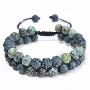 Detail of double-layer woven bracelet with grey lava stones and green spotted beads