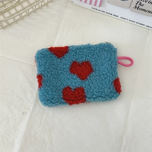 Detail of blue plush heart coin purse with soft fleece texture and pink zipper puller