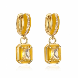 Detailed macro view of gold plated earrings featuring yellow enamel and cubic zirconia