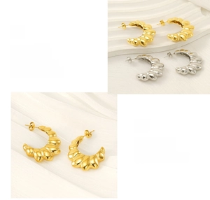 Close-up of polished C-shaped ribbed stud earrings in gold and silver stainless steel