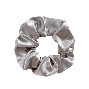 Detailed view of silver grey satin fabric texture and folds on a large hair scrunchie