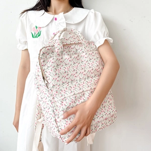 Close-up of fresh floral pattern and soft fabric texture on the stylish white backpack