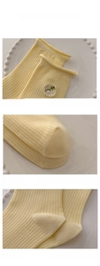 Detailed views of cotton socks showing ribbed cuffs, floral embroidery and reinforced toe