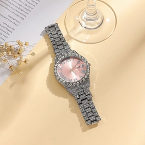 Elegant iced out ladies watch with pink dial, Roman numerals, and calendar date window