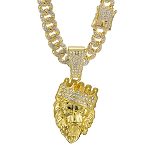 Iced out gold Cuban link necklace featuring a crown lion head pendant with clear rhinestones