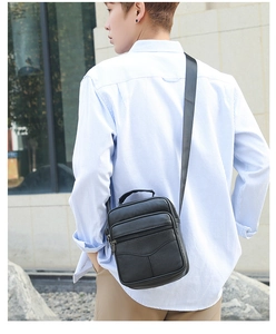 Outdoor shot of a man wearing a black lychee texture leather crossbody shoulder bag