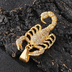 Vue macro d'un pendentif scorpion doré orné de strass brillants sur roche noire