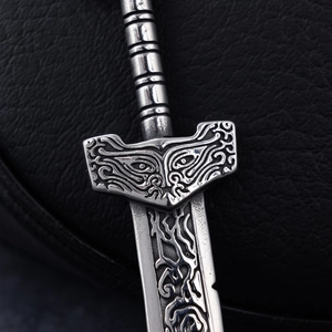 Vintage stainless steel broken sword pendant with intricate embossed details on black leather