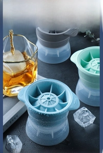 Detailed view of colorful TPR sphere ice molds with whiskey glasses for home use