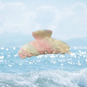 Pince à cheveux colorée en acétate avec texture marbrée flottant sur les vagues