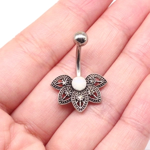 Silver mandala fan belly button ring with white opal and rhinestones held in hand