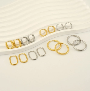 Detail view of gold and silver stainless steel hoop earrings with textured finish