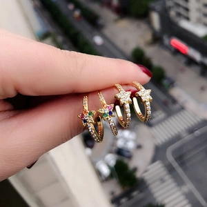 Macro shot of gold star hoop earrings with colorful and white cubic zirconia accents