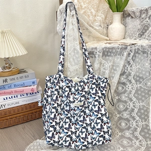 Close-up of butterfly print tote bag with drawstring detail in elegant indoor setting