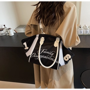 Rear view of a model carrying the black and white nylon bowling bag in a cafe setting