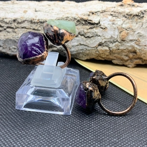 Detailed macro view of vintage bronze rings with amethyst and green fluorite raw stones