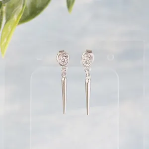 Macro shot of 925 silver spike earrings with round zircon inlay on a display stand