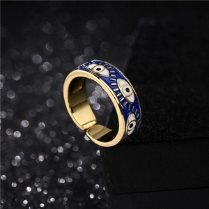 Golden evil eye open ring with blue enamel detailing shown from a 45-degree angle