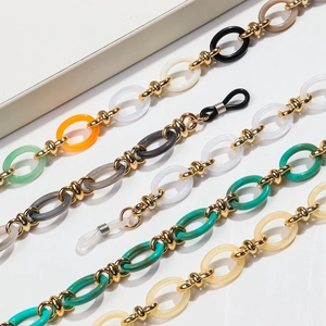Detailed macro view of bohemian acrylic eyeglass chains with golden metal link connectors