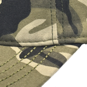 Macro detail of jungle camo baseball cap with precise double-row stitching on canvas