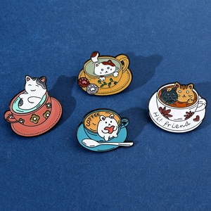 Detail showing four colorful enamel pins featuring cats and rabbits in coffee cups