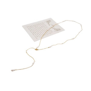 Elegant gold freshwater pearl necklace with flowing long pendant on a clean white background