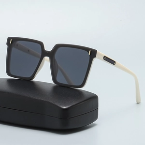 Modern square oversized sunglasses with two-tone black and cream frame on a black case
