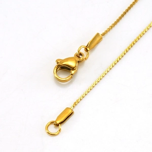 Macro shot of gold-plated stainless steel chain featuring a secure lobster clasp