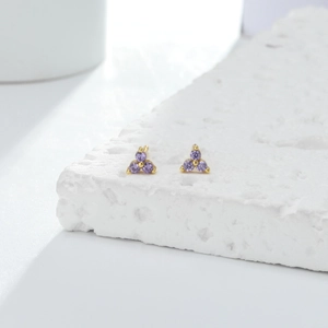 Detailed macro shot of mini S925 sterling silver triangle stud earrings with purple zircons.
