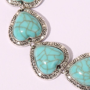 Macro shot of vintage heart-shaped turquoise stone set in ornate silver metal link