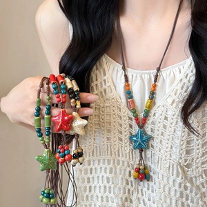 Détail de pendentifs étoile de mer en céramique colorée et perles sur colliers en corde