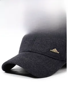 Detailed side view of charcoal grey wool cap with golden Sport Spirit metal emblem