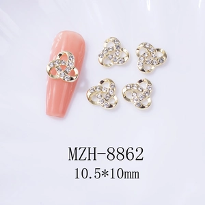 Détail des charms pour ongles en alliage doré avec strass blancs et design ajouré