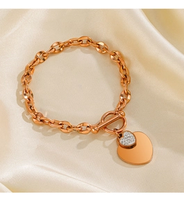 Détail du bracelet pendentif coeur en or rose avec cristaux sur fond de soie