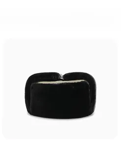 Detail view of a black faux fur trapper hat with folded ear flaps and warm lining