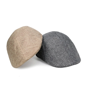 Detail of light brown and gray flat caps showing breathable linen-cotton weave texture